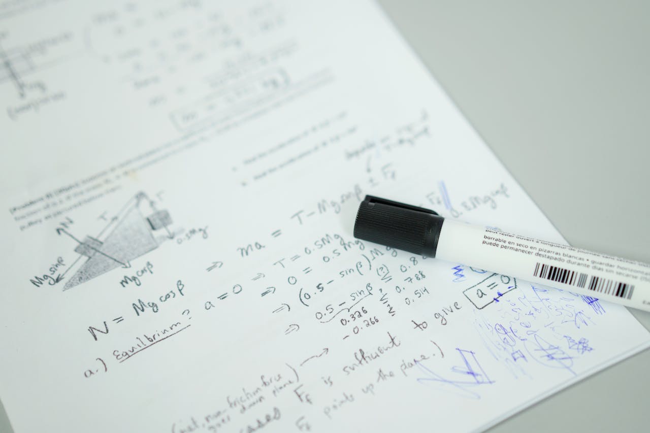 Close-up showing mathematical formulas and a marker on bond paper, ideal for education themes.