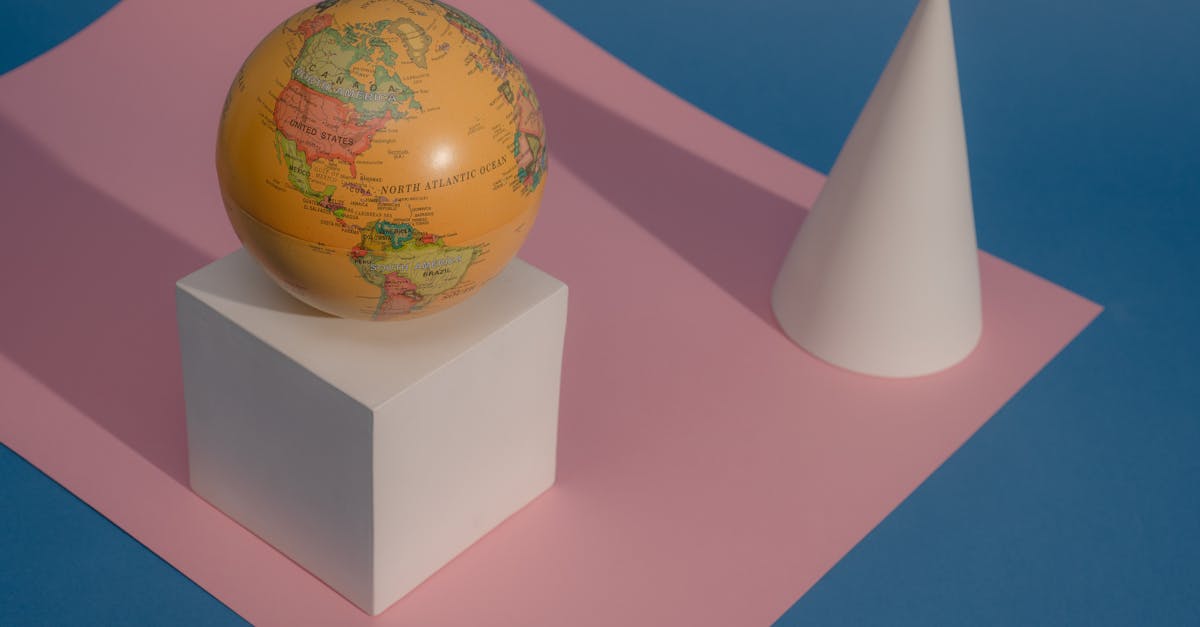 Artistic composition of a globe and geometric shapes on colorful paper background.